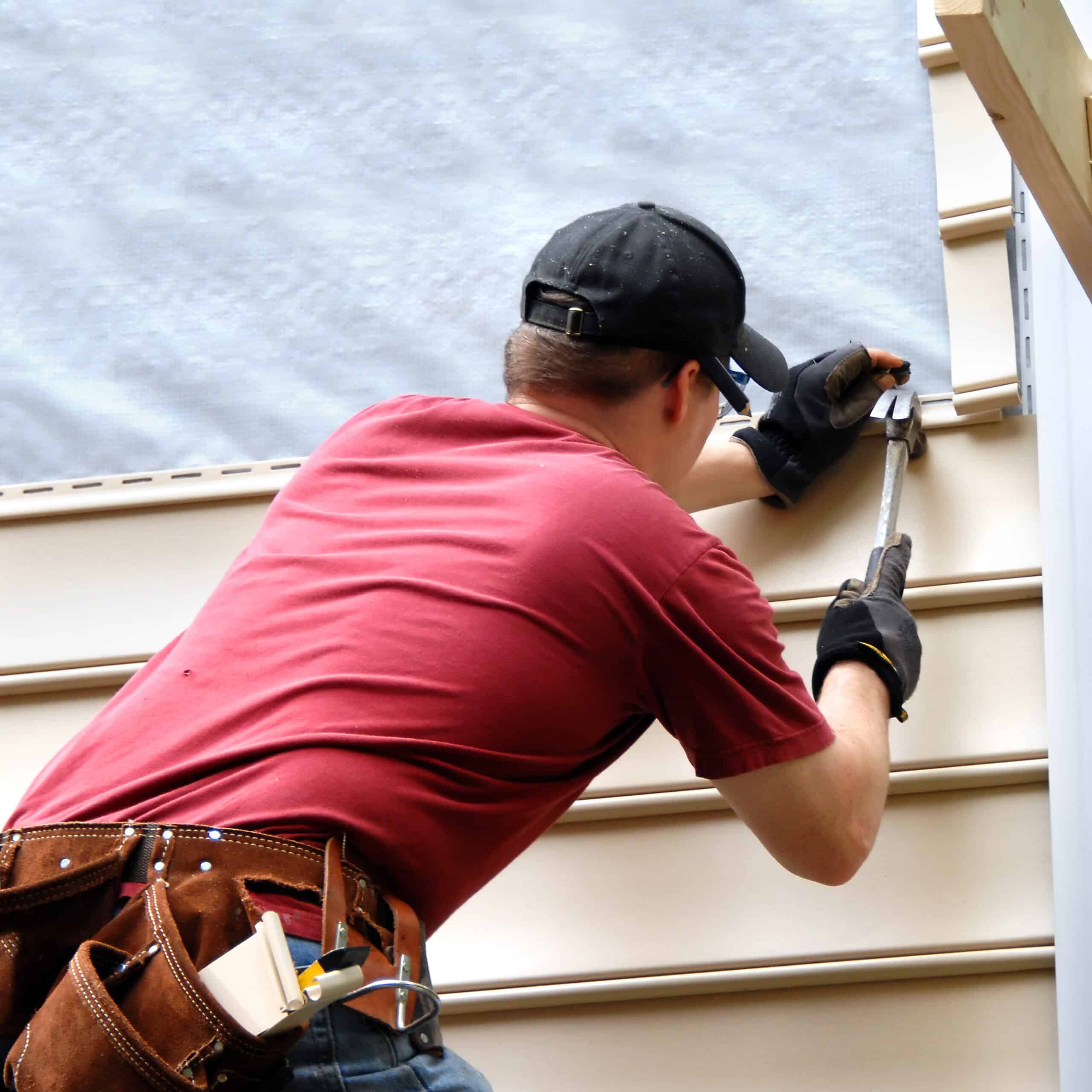 siding contractor installing siding on house exterior