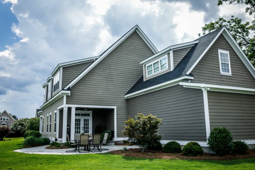 newly installed grey house siding with clouds on the sky