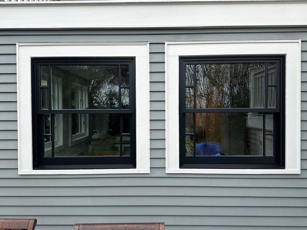 2 windows with white trim and lap siding around