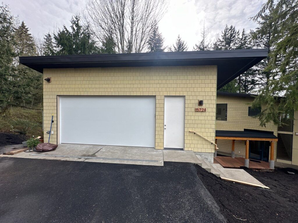 garage and shingle siding with black fascia and windows details
