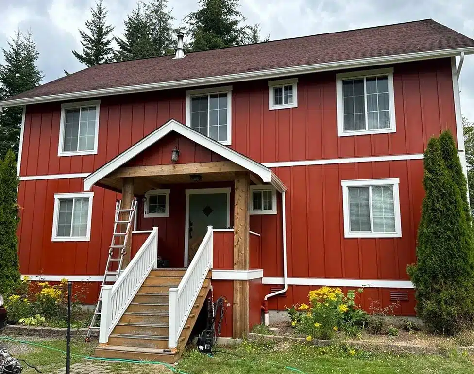 Red two-story house with stairs, house exterior with board and batten