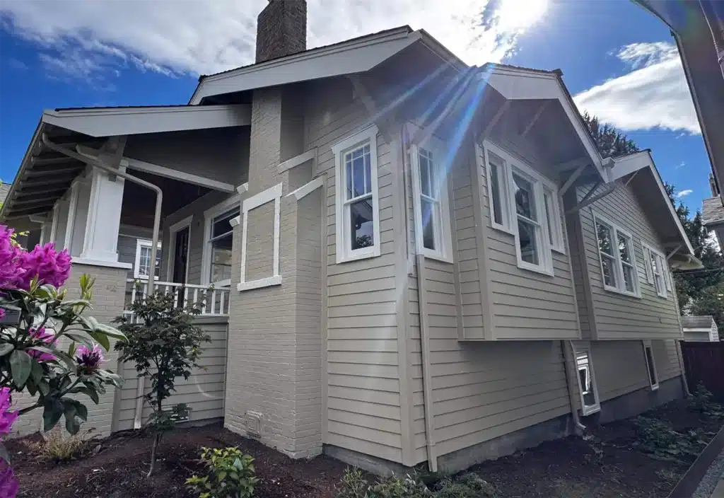 Two coats of Sherwin-Williams Emerald in two colors, with painted brick, chimney, steps, siding body, eaves, trim, fascia, and corners finish on Queen Anne, Seattle, WA siding remodel